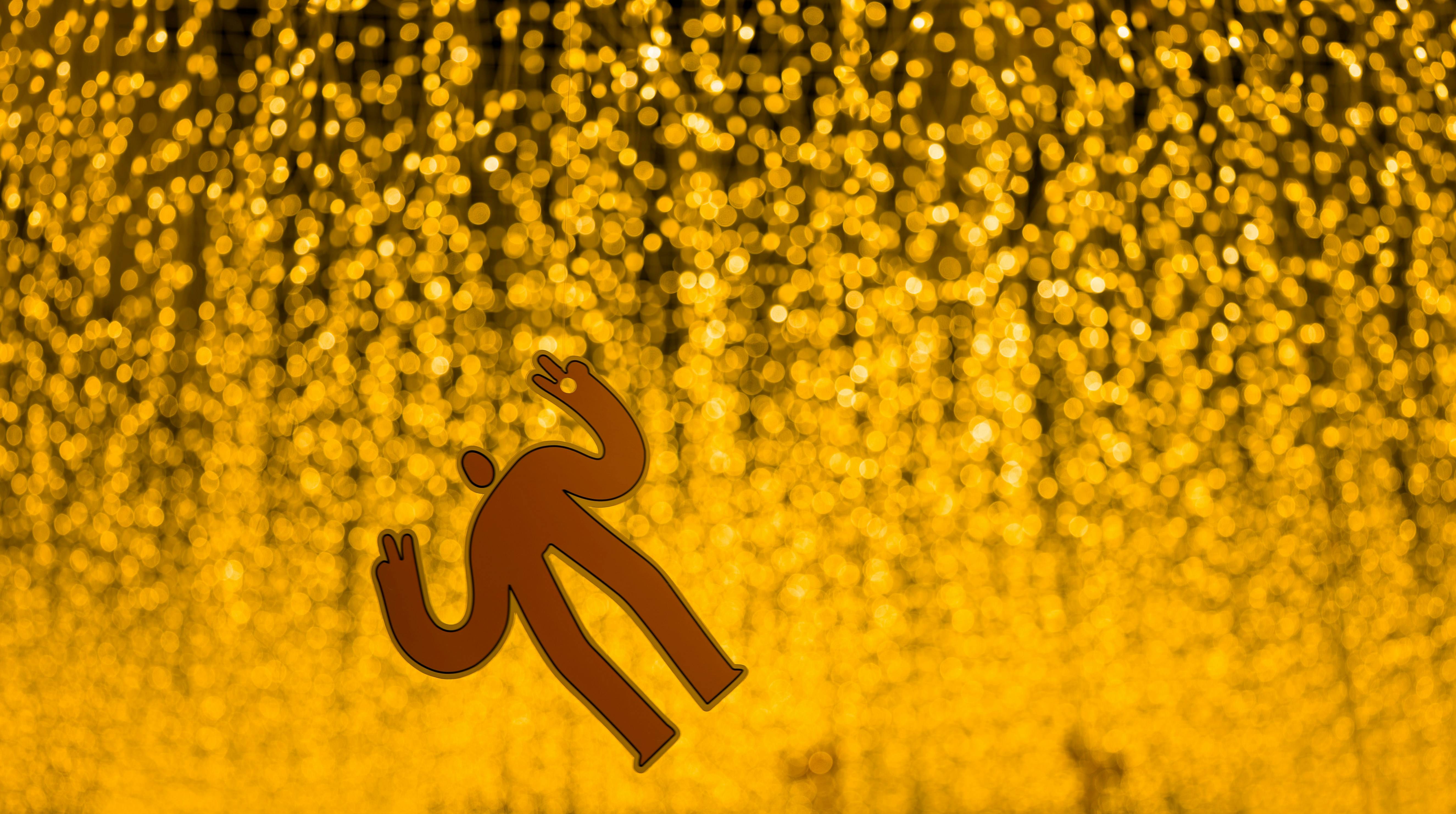 A silhouette falls against a gold backdrop.